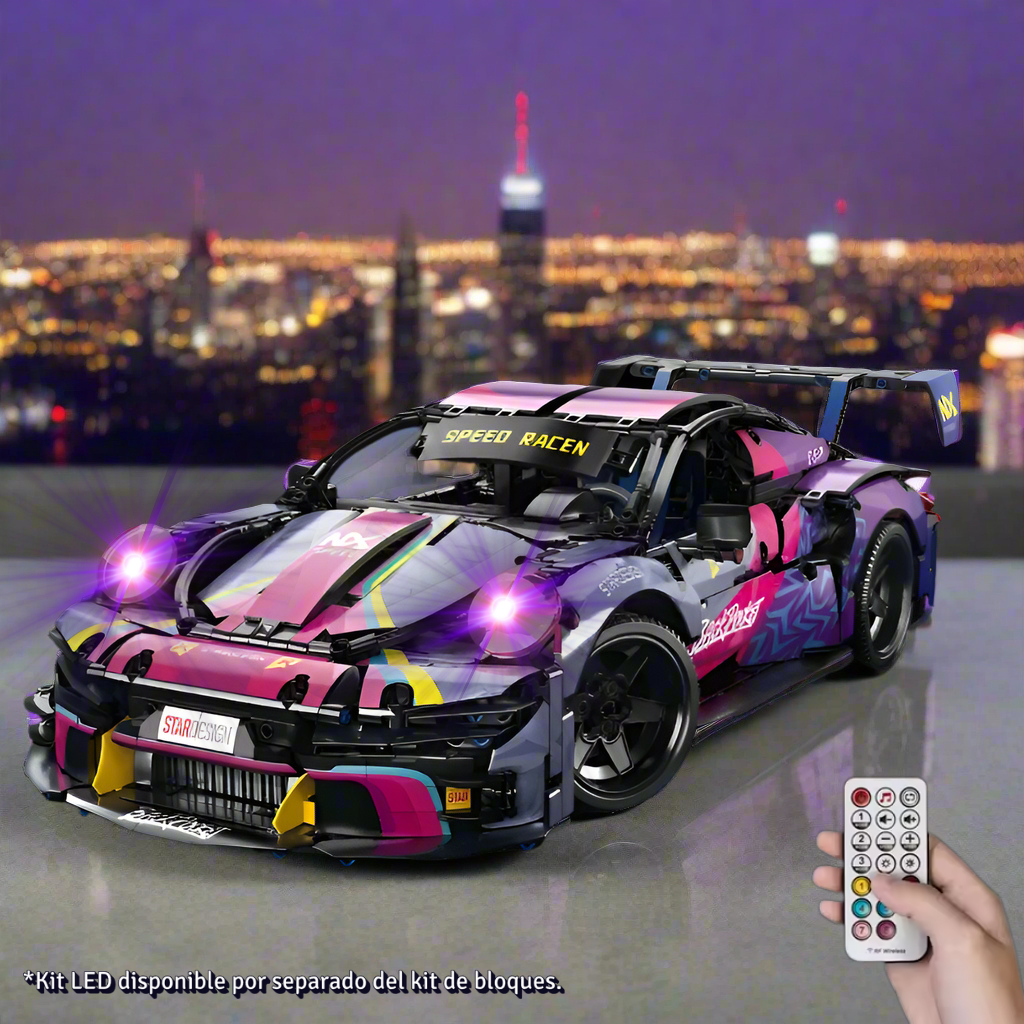 Toy race car with colorful design and remote control in front of a city skyline at night.